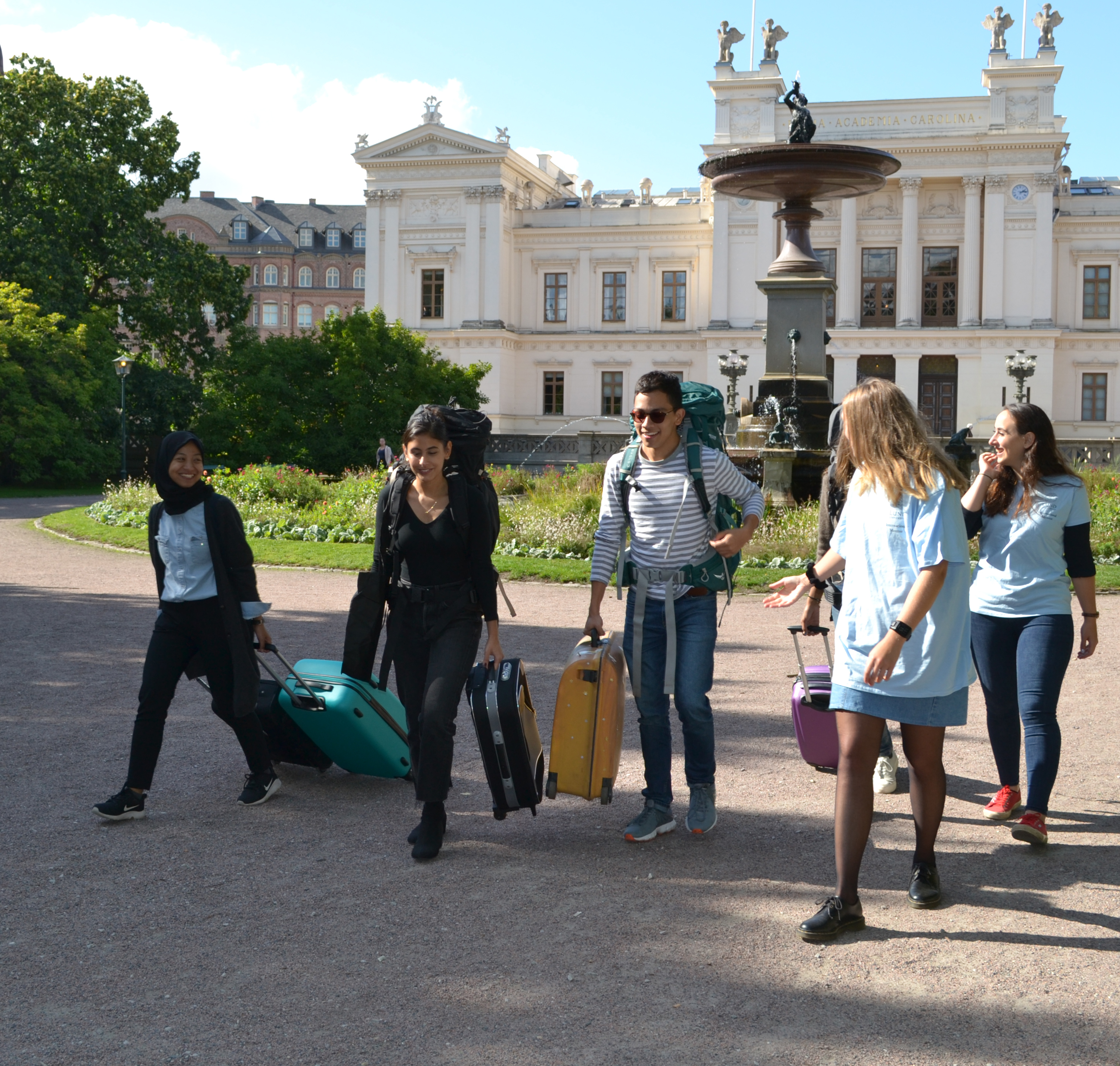 Studenter framför Universitetshuset en solig dag. Foto. 