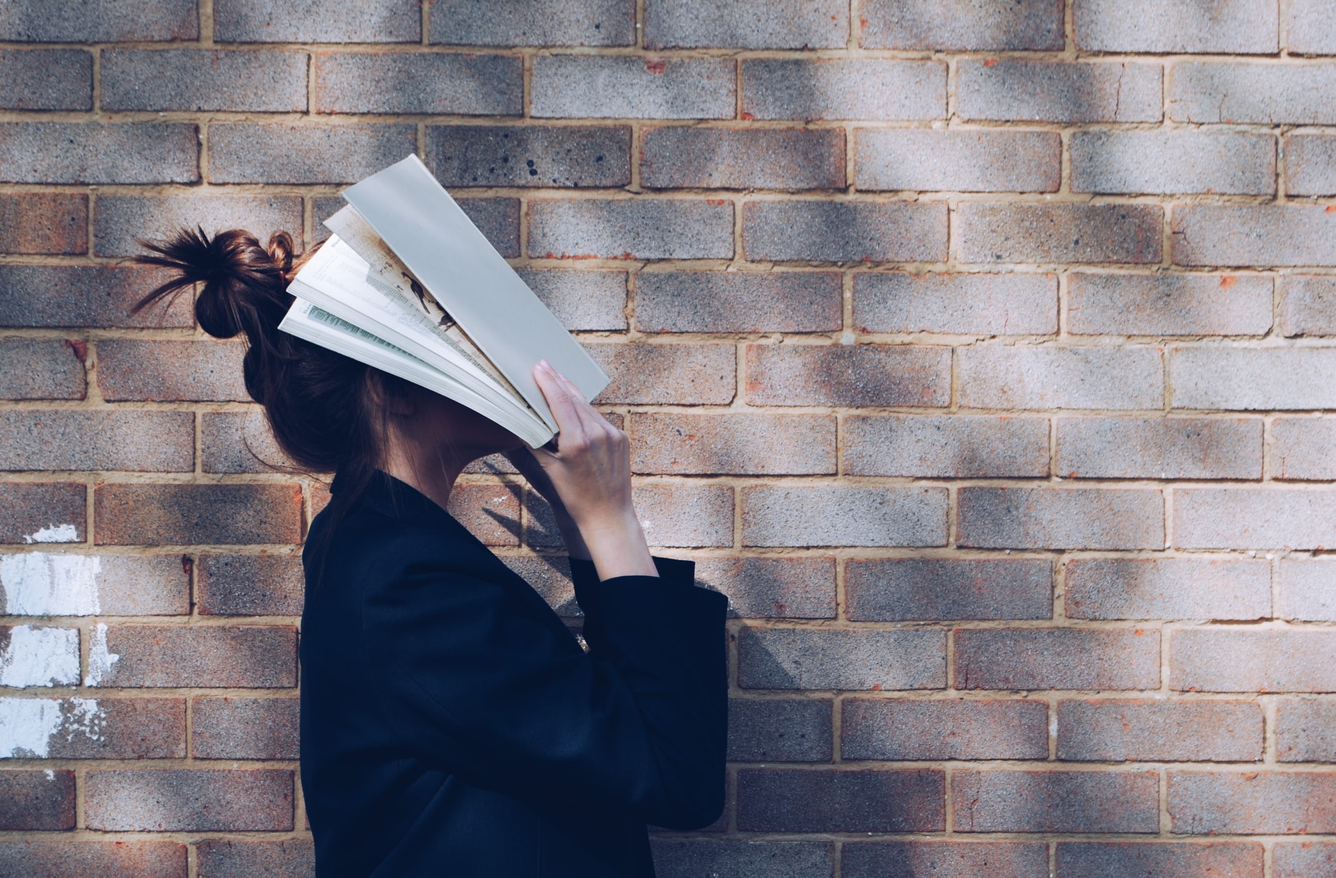 Student håller i en bok. Foto: Unsplash.